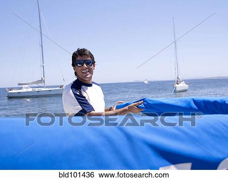 Hispanic man working on sailboat View Large Photo Image Stock Photograph - Hispanic man working on sailboat. Fotosearch