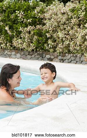Stock Photo - Hispanic mother and son enjoying swimming pool. Fotosearch