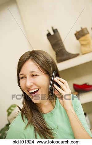 Hispanic woman talking on cell phone in shoe store View Large Photo Image Picture - Hispanic woman talking on cell phone in shoe store. Fotosearch