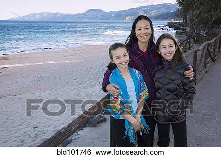 Stock Photograph - Japanese family standing on beach. Fotosearch