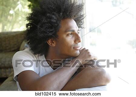 Stock Photography - Man sitting on sofa thinking. Fotosearch
