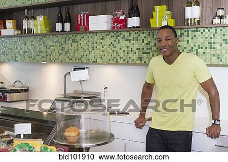 Mixed race business owner leaning on shop counter View Large Photo Image Stock Image - Mixed race business owner leaning on shop counter. Fotosearch