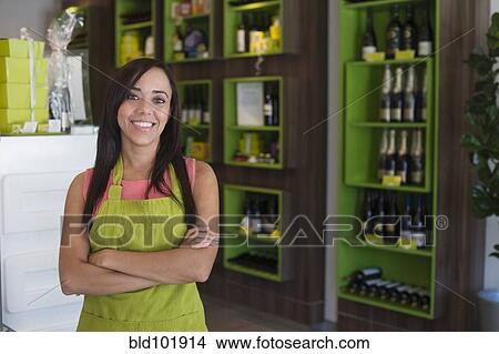 Picture - Mixed race business owner standing in shop. Fotosearch