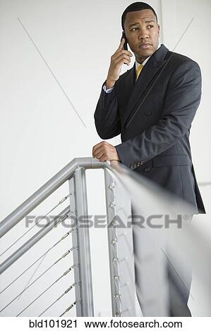 Stock Image - Mixed race businessman talking on cell phone. Fotosearch