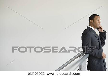 Stock Image - Mixed race businessman talking on cell phone. Fotosearch