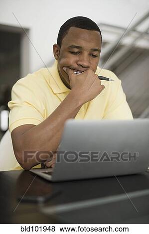 Mixed race businessman using laptop View Large Photo Image Stock Photo - Mixed race businessman using laptop. Fotosearch