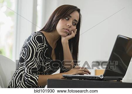 Stock Image - Mixed race businesswoman typing on laptop. Fotosearch