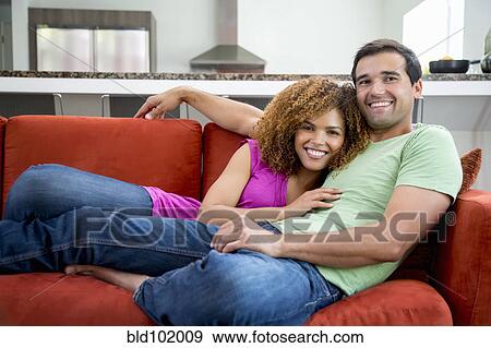 Mixed race couple laying on sofa together View Large Photo Image Stock Photo - Mixed race couple laying on sofa together. Fotosearch