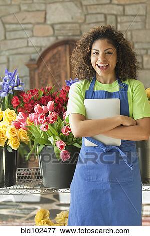 Stock Photo - Mixed race florist holding digital tablet. Fotosearch