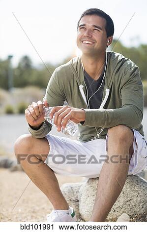 Mixed race man drinking water after exercise View Large Photo Image Stock Image - Mixed race man drinking water after exercise. Fotosearch