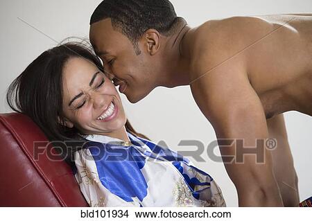 Picture - Mixed race man kissing girlfriend. Fotosearch