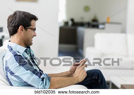 Stock Photography - Mixed race man text messaging on cell phone. Fotosearch