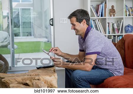 Stock Photo - Mixed race man using digital tablet. Fotosearch