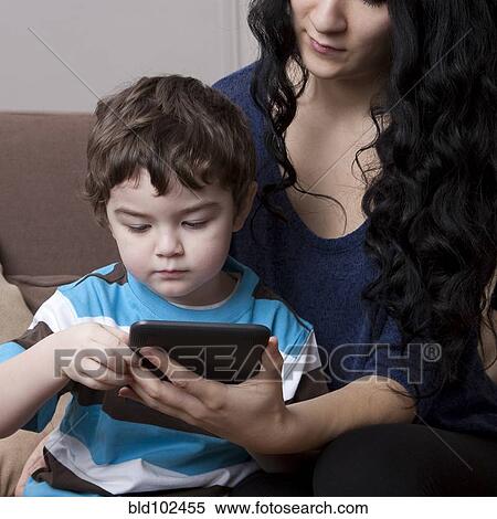 Stock Photography - Mixed race mother and son using digital tablet. Fotosearch