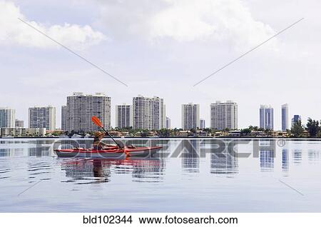 Picture - Mixed race woman in kayak on river. Fotosearch