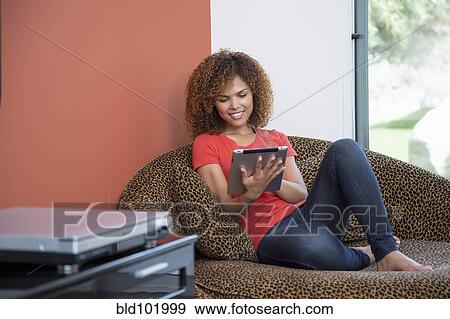 Stock Photo - Mixed race woman using digital tablet. Fotosearch