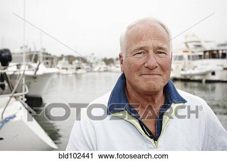 Stock Image - Serious man in marina. Fotosearch