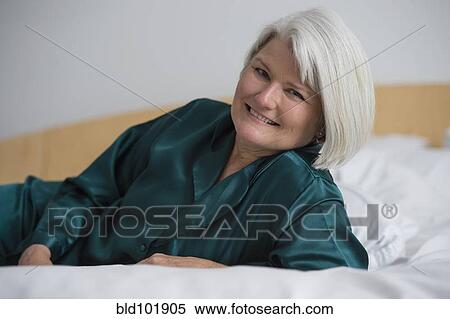 Smiling Caucasian woman laying in bed View Large Photo Image Stock Photography - Smiling Caucasian woman laying in bed. Fotosearch