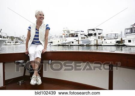 Smiling woman sitting on boat View Large Photo Image Stock Photo - Smiling woman sitting on boat. Fotosearch