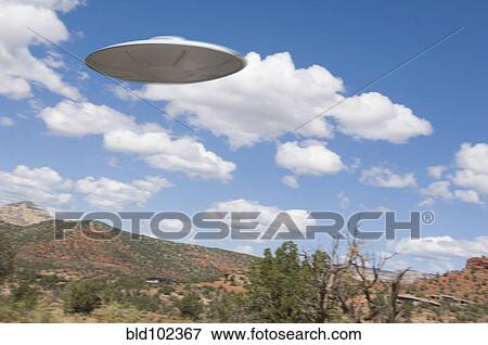 Stock Photo - UFO flying over desert. Fotosearch