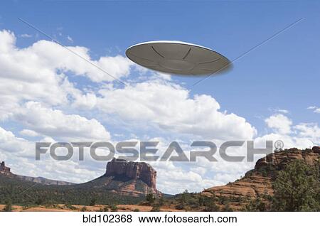 Stock Photo - UFO flying over desert. Fotosearch