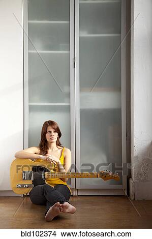 Woman sitting on floor with guitar View Large Photo Image Picture - Woman sitting on floor with guitar. Fotosearch