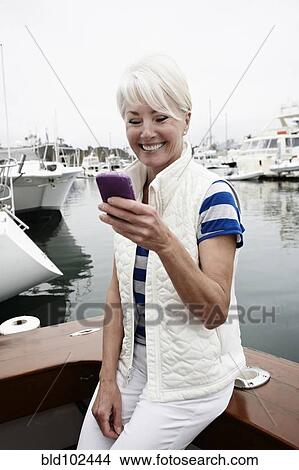 Woman using cell phone in marina View Large Photo Image Picture - Woman using cell phone in marina. Fotosearch