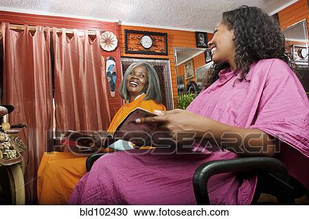Stock Image - Women reading magazines in beauty salon. Fotosearch