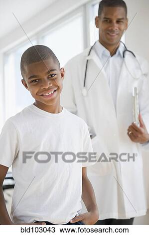 Stock Image - African American boy having checkup with doctor. Fotosearch