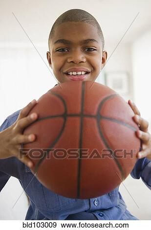 Stock Photo - African American boy holding basketball. Fotosearch