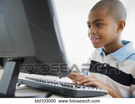 Stock Image - African American boy using computer. Fotosearch