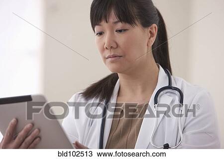 Asian doctor using digital tablet View Large Photo Image Stock Image - Asian doctor using digital tablet. Fotosearch