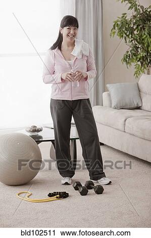 Stock Image - Asian woman relaxing after exercise. Fotosearch