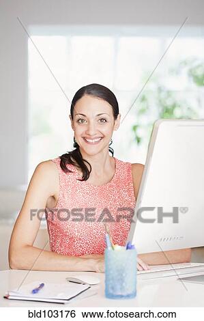Caucasian businesswoman sitting at desk View Large Photo Image Stock Photograph - Caucasian businesswoman sitting at desk. Fotosearch