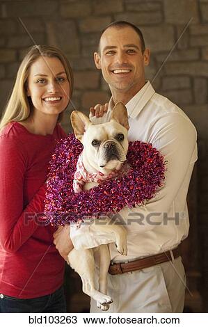 Caucasian couple holding dog View Large Photo Image Stock Image - Caucasian couple holding dog. Fotosearch