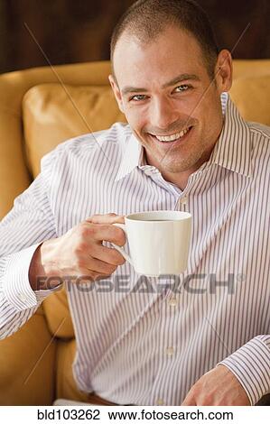Stock Image - Caucasian man drinking coffee. Fotosearch