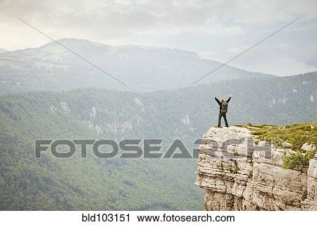 Caucasian man standing on remote cliff View Large Photo Image Stock Image - Caucasian man standing on remote cliff. Fotosearch