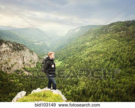 Caucasian man standing on remote cliff View Large Photo Image Stock Photo - Caucasian man standing on remote cliff. Fotosearch