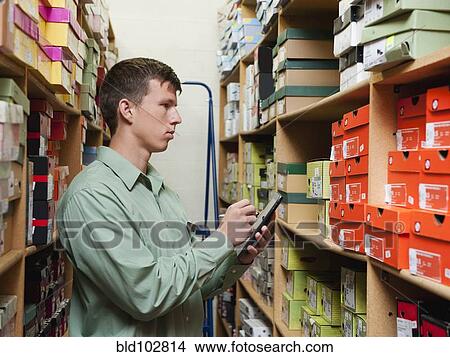 Picture - Caucasian man working in stockroom. Fotosearch