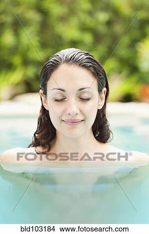 Picture - Caucasian woman enjoying swimming pool. Fotosearch