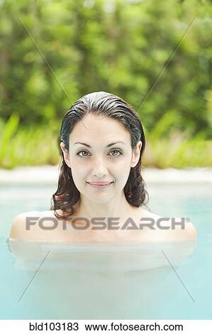 Stock Image - Caucasian woman enjoying swimming pool. Fotosearch
