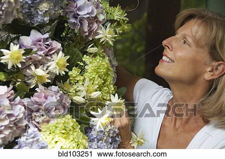 Caucasian woman looking at flowers View Large Photo Image Stock Image - Caucasian woman looking at flowers. Fotosearch