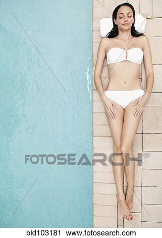 Caucasian woman lying at poolside View Large Photo Image Stock Image - Caucasian woman lying at poolside. Fotosearch