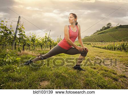 Stock Photo - Caucasian woman stretching in vineyard. Fotosearch