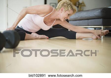 Caucasian woman stretching on floor View Large Photo Image Stock Image - Caucasian woman stretching on floor. Fotosearch