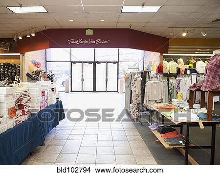 Picture - Clothes and shoes displayed in clothing store. Fotosearch