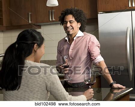 Couple drinking red wine in kitchen View Large Photo Image Stock Photo - Couple drinking red wine in kitchen. Fotosearch
