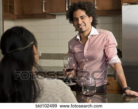 Couple drinking red wine in kitchen View Large Photo Image Stock Photo - Couple drinking red wine in kitchen. Fotosearch