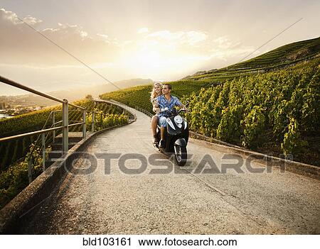 Couple riding scooter in vineyard View Large Photo Image Stock Image - Couple riding scooter in vineyard. Fotosearch