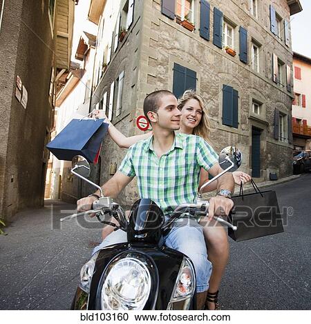 Couple riding scooter together View Large Photo Image Stock Image - Couple riding scooter together. Fotosearch